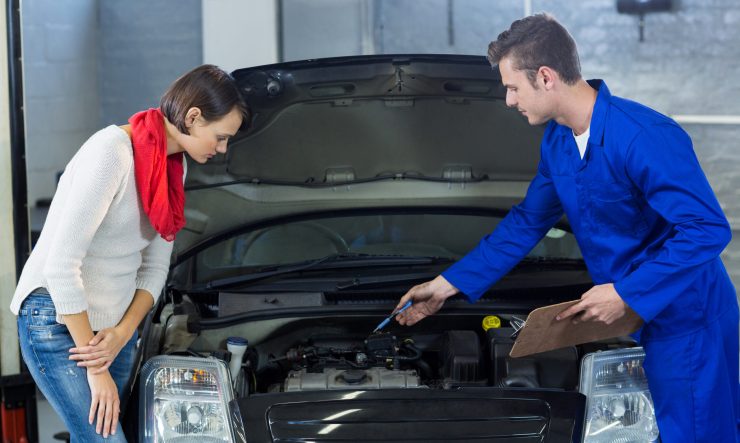 Mechanic showing customer the problem with car Mechanic showing customer the problem with car in repair garage